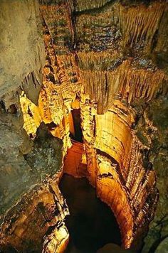 the inside of an underground cave with water and rock formations on it's sides