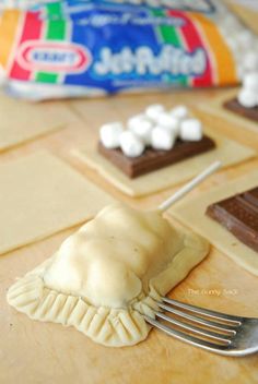 there are marshmallows and chocolate on the table with candy bars in the background