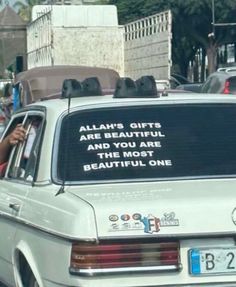 a white car parked on the side of a road with a sign that says, allaah's gifts are beautiful and my mom is beautiful one