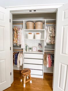 an open closet with clothes and baskets on the shelves, next to a step stool