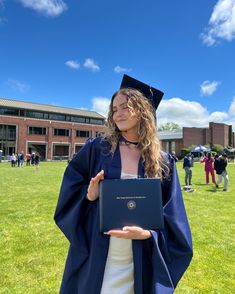 a woman in graduation gown holding a book