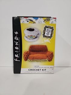 a crochet kit with a couch and plate on the table next to it