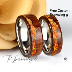 two wooden rings with autumn leaves inlayed on them, sitting next to each other