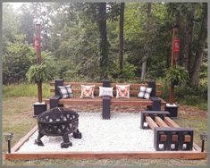 a wooden bench sitting in the middle of a park filled with lots of plants and pillows