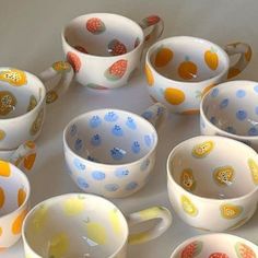 a table topped with lots of colorful cups and saucers