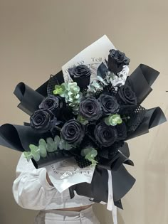 a woman holding a bouquet of black roses