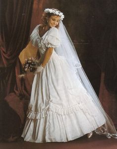 a woman in a wedding dress posing for a photo