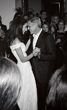 a man and woman dance together in front of a large group of people at a party