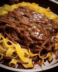 a bowl filled with pasta and beef in sauce