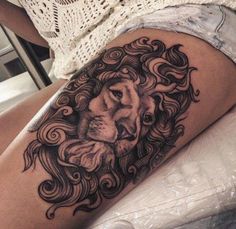 a woman's thigh with a lion tattoo on it