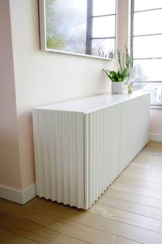 a long white radiator in front of a window