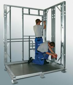 two men working on the inside of a metal structure