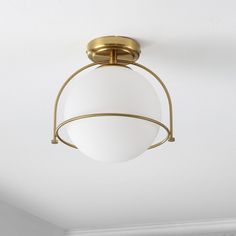 a light fixture hanging from the ceiling in a room with white walls and flooring