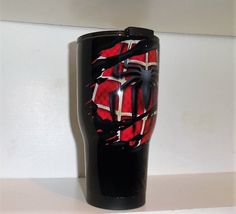 a black and red vase sitting on top of a white counter next to a wall