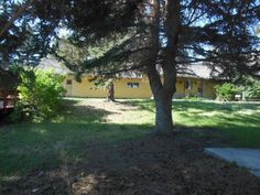 a yellow house with trees in front of it