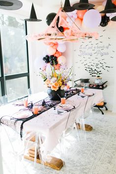 a party table with balloons and decorations