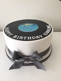 a white cake with black and grey ribbon around it