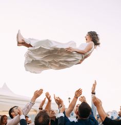 a woman flying through the air while surrounded by people