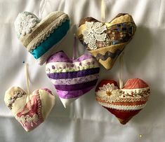 four decorative heart shaped ornaments hanging from clothes pins