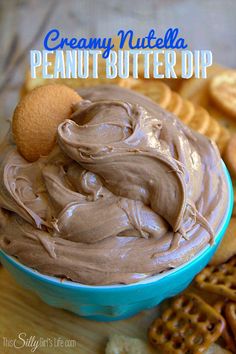 a bowl filled with peanut butter dip surrounded by crackers