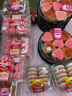 some heart shaped cookies are on display in plastic containers