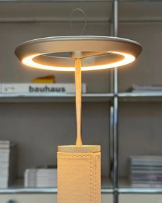 a lamp that is sitting on top of a table in front of a book shelf