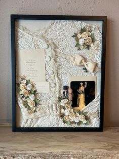 a framed photo with flowers and lace on it