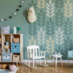 a child's room decorated in blue, green and white with an animal themed wallpaper