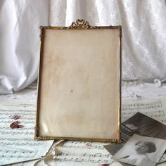 an old photo frame sitting on top of sheet music