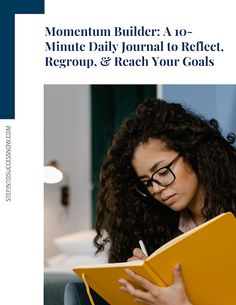 a woman sitting on the floor with a book in her hand and writing something down