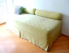 a bed sitting on top of a hard wood floor next to a window in a room