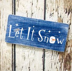 a wooden sign that says let it snow with a snowman in the center and stars