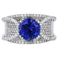 Luxury awaits in this extraordinary White Gold Tanzanite Pave Diamond Estate Ring! Captivating with its 3.49ct Tanzanite center, the design is further accentuated with 274 Round Brilliant Cut Pave Diamonds. Size 7.25. 18kt White Gold. Indulge in true excellence! White Gold Tanzanite Diamond Ring 3.49ct Tanzanite in the center 274pcs Round Brilliant Cut Pave Diamonds Diamonds: estimated 1.10ct TW G/H VS2 / SZ 7.25 18kt. White gold Estate Collection Size 7.25 Tanzanite Diamond Ring, Estate Rings, Tanzanite Diamond, Pave Ring, G H, White Gold Rings, Cocktail Rings, Tanzania, Pave Diamonds