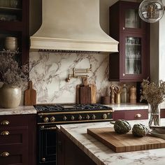 a kitchen with marble counter tops and dark wood cabinets, along with an oven hood