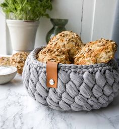 some food is in a basket on a table next to a potted plant and a bowl