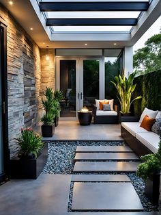 an outdoor living area with stone steps and potted plants on either side of the patio