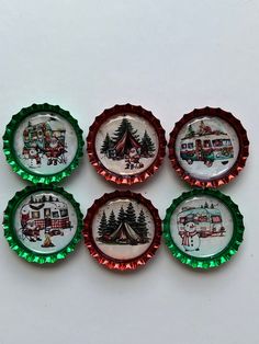 six bottle caps decorated with campers and christmas trees in green, red, and white