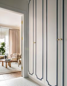 an open door leading to a living room with white walls and blue trim on the doors