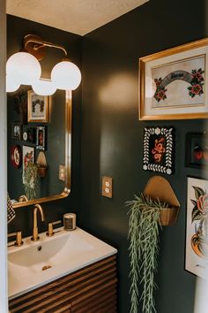 a bathroom sink sitting under a mirror next to a wall mounted art on the wall