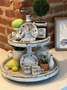 a tray with plates and cups on it sitting on a table next to a brick wall