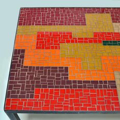 a table that has some kind of colorful design on top of it, and is made out of bricks