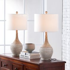 two lamps sitting on top of a wooden table