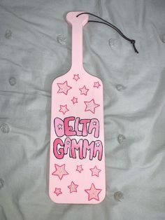 a pink tag that says delta gam on it with stars around it and the words delta gam written in pink