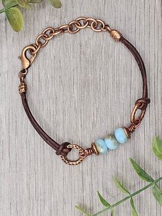 Czech Glass Aqua Opal Celsian beads with antique copper accents on antique brown leather bracelet.  This bracelet has a size fit of approximately 7 inches to 7 1/2 inches. To keep beads, leather and all other components looking their best, avoid contact with water, lotions and perfumes. To access all other items in my shop, just hit the link here: https://www.etsy.com/ca/shop/KootenayLeatherRHS If you like jewelry, check out my other Etsy shop...it's jewelry for your door!  www.etsy.com/ca/shop/ Adjustable Brown Jewelry With Patina, Adjustable Brown Patina Jewelry, Handmade Adjustable Vintage Brown Jewelry, Patina Brown Bracelet Jewelry, Brown Patina Bracelet Jewelry, Adjustable Rustic Bronze Bracelets, Bohemian Brown Metal Beaded Bracelets, Rustic Adjustable Bronze Bracelets, Brown Patina Bracelet