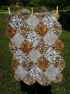 an animal print quilt hanging on a clothes line