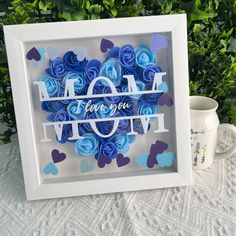 a white frame with blue flowers and the words i love you