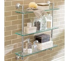 glass shelves in the bathroom with towels, soaps and other items on top of them