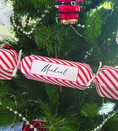 a christmas tree with red and white candy canes hanging from it's branches