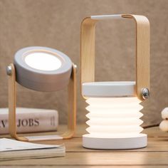 a white light sitting on top of a wooden table next to a pile of books