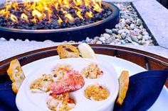 a white plate topped with food next to a fire pit